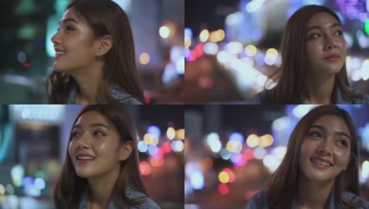 微笑的年轻美丽的亚洲女性游客走在城市的夜晚，看着路灯照明。快乐的漂亮女孩享受和享受城市夜生活的乐趣。高清在线视频素材下载