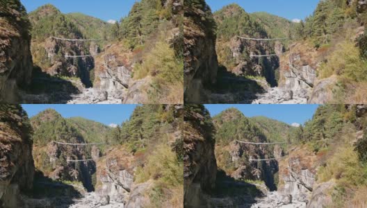 在通往尼泊尔纳姆切巴扎的喜马拉雅山上，喜马拉雅山上布满岩石的Dudhkoshi河谷上，可以看到著名的希拉里吊桥。高清在线视频素材下载
