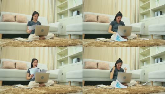 一名亚洲妇女在膝上放着笔记本电脑完成工作后将文件扔进客厅。高清在线视频素材下载