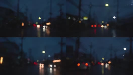 关闭了。下雨天在路上开车。从车流中聚集的模糊光线，雨水打在前镜上。视频缓慢的运动。高清在线视频素材下载