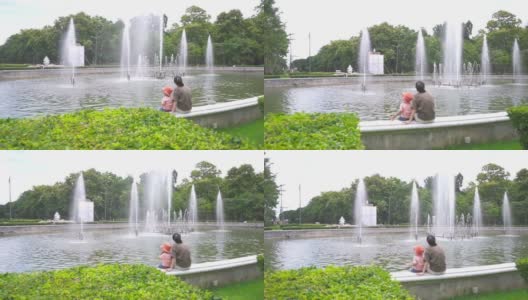 小男孩和妈妈坐在公园里一起看喷泉高清在线视频素材下载