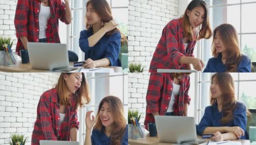 亚洲同事友谊在工作中笑脸相迎。幸福两个女同事一起工作，小组会议在办公桌上。团队业务伙伴与电脑笔记本电脑创业公司高清在线视频素材下载