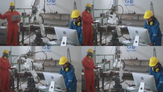 多种族的工程师在工厂工作，用电脑和平板检查焊接机器人手臂。经理工程师检查和控制仓库自动化机器人手臂机器高清在线视频素材下载