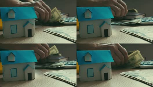 抵押贷款的概念。房子的模型和数钱的过程。房地产贷款。高清在线视频素材下载