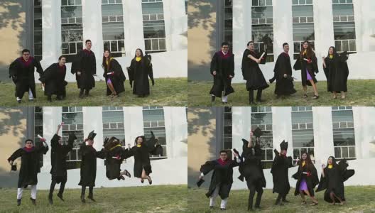 成功的毕业生穿着学位服，拿着学位证书，看着相机，微笑着跳到户外拍照。高清在线视频素材下载