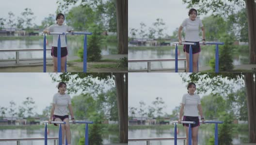 女人在公园的健身机上玩高清在线视频素材下载