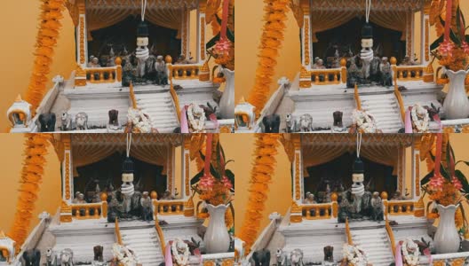 泰国园林中的传统佛坛装饰精美，有鲜花和各种象征人物高清在线视频素材下载