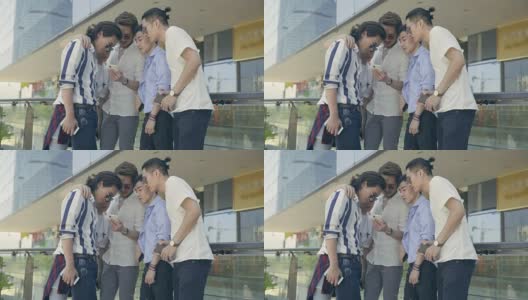年轻的亚洲成年男子在街上闲逛，看手机高清在线视频素材下载