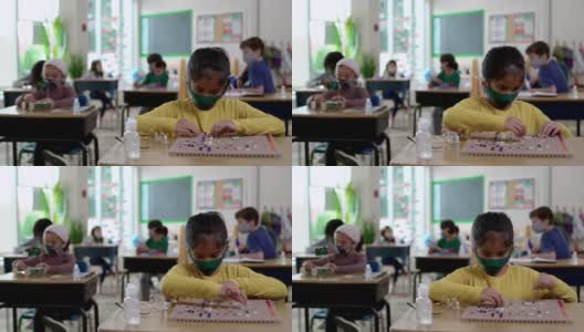 2019冠状病毒病期间，戴口罩的学生在教室里高清在线视频素材下载