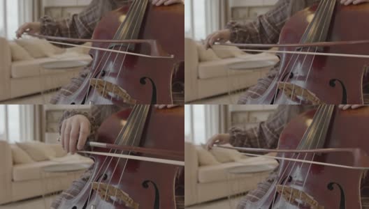 年轻女子音乐家与弓在家里演奏大提琴高清在线视频素材下载