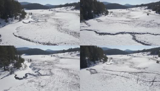 冬天，在松林中，空中盘旋在蜿蜒的河床上。在山上滑雪度假。高清在线视频素材下载