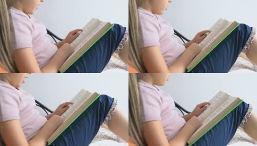 女孩一边看书，一边指着书上的课文高清在线视频素材下载