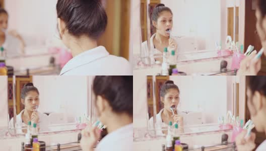 印度年轻女子对着镜子刷牙。高清在线视频素材下载