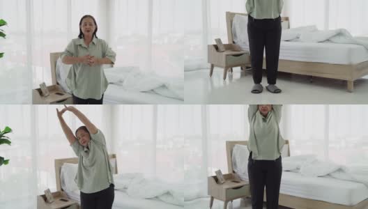 打开老年妇女早上醒来后在卧室里锻炼的视频。高清在线视频素材下载