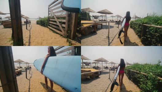 年轻女子手拉冲浪板和走在海边的背影高清在线视频素材下载