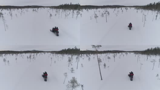 近:一对夫妇的后视图雪上摩托穿越白色的冬天景观高清在线视频素材下载