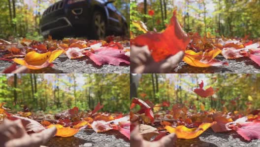 慢镜头:SUV汽车行驶在秋天的森林里，在路上旋转着五颜六色的树叶高清在线视频素材下载
