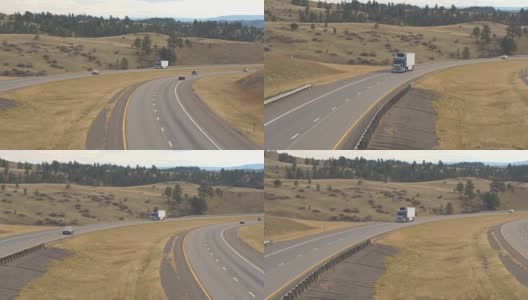 卡车和汽车在高速公路上驶近落基山脉高清在线视频素材下载