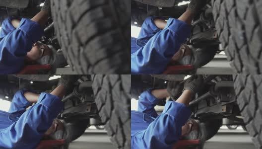 摄影:亚洲高级汽车技师在车下工作高清在线视频素材下载