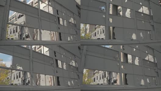 靠近:废弃工厂中破碎的窗户，破损的立面和破碎的墙壁高清在线视频素材下载