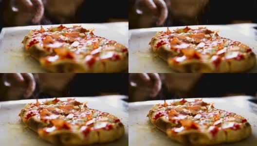 慢动作视频。厨师的手在披萨上撒香料高清在线视频素材下载