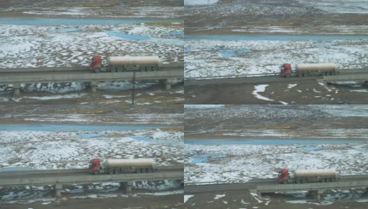 慢镜头:一辆旧的红色货车穿过一个充满小溪的大平原。高清在线视频素材下载