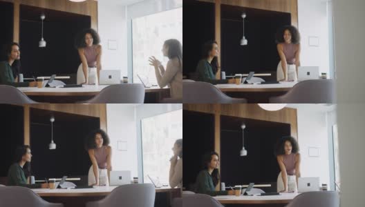 三名女商人在办公室的桌子周围社交距离会议通过门口观察-用慢镜头拍摄高清在线视频素材下载