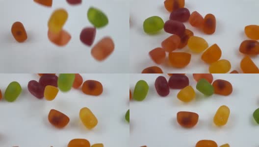 五颜六色的果冻糖慢慢地落在白色的盘子上，慢镜头高清在线视频素材下载
