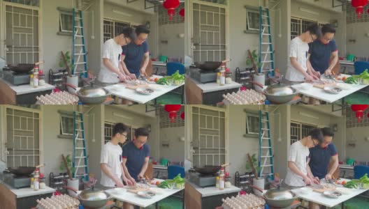 周末的时候，亚洲华人父亲和儿子在自家后院的厨房做饭，为家人准备晚餐高清在线视频素材下载