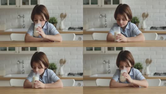 可爱的口渴的小男孩喝着一杯牛奶。高清在线视频素材下载