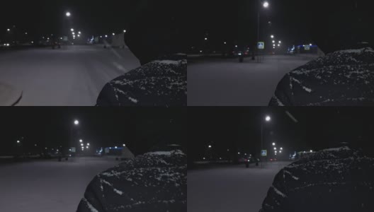 暴风雪。在冬天下雪的时候，一个人在夜晚的城市里沿着积雪覆盖的道路行走。暴雪。天气恶劣，气候寒冷。城市街道照明用路灯。手持拍摄的高清在线视频素材下载