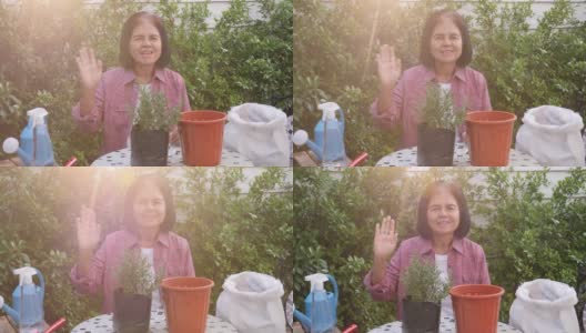 肖像拍摄一位快乐的退休亚洲资深妇女挥手，户外种植活动的概念高清在线视频素材下载