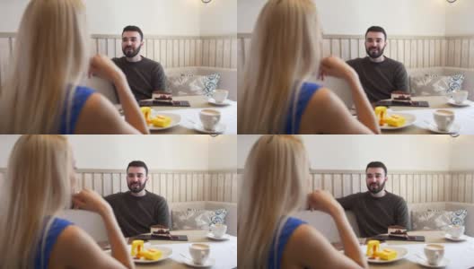 一个年轻的白人男人在咖啡馆里和一个女人聊天高清在线视频素材下载