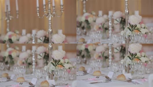 为婚礼或周年纪念招待会设置的节日餐桌烛台和鲜花靠近浅景深的场垂直锅。为几位客人安排餐具高清在线视频素材下载