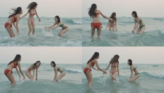 一群快乐的女孩朋友在沙滩上玩水。美丽的亚洲女孩在暑假。庆祝和放松的概念。高清在线视频素材下载