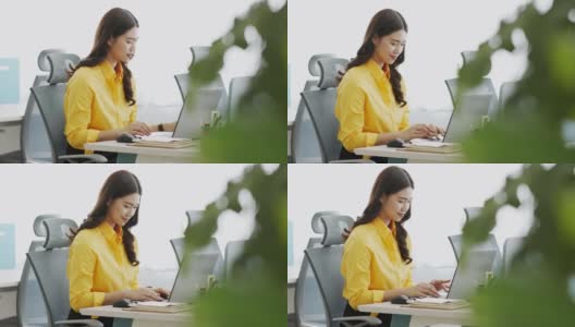 幸福迷人的亚洲女人在黄色衬衫喝咖啡与电脑笔记本思考得到想法和需求在现代办公室或联合办公空间创业高清在线视频素材下载