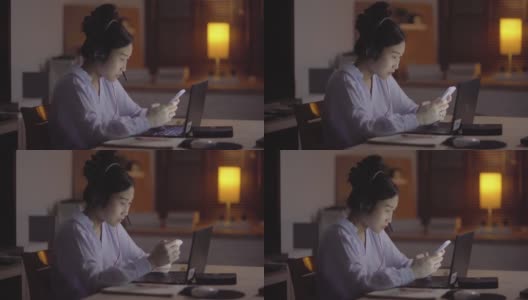年轻的亚洲女人一边做家庭预算，一边工作到深夜高清在线视频素材下载