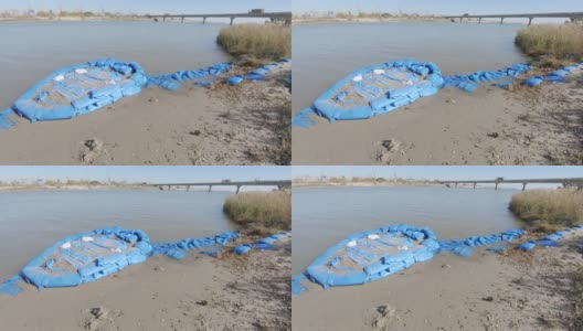 用蓝色塑料袋和沙子加固河岸高清在线视频素材下载