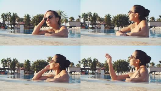 一个阳光明媚的夏日，年轻的黑发女子穿着比基尼在泳池里高清在线视频素材下载