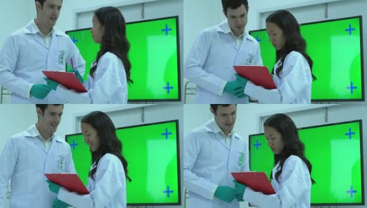 科学家谈论在现代实验室或医疗中心工作。背景显示器绿屏。科学的理念，测试发展和实验室产业。高清在线视频素材下载