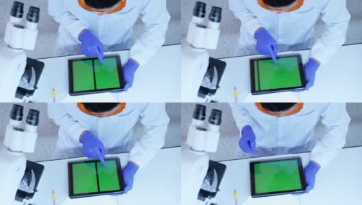 科学家在实验室使用带绿色屏幕的平板电脑高清在线视频素材下载