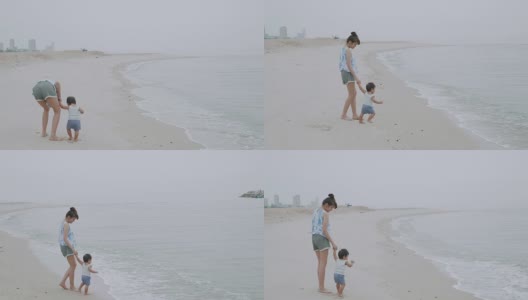 母亲和男婴在华欣海滩散步高清在线视频素材下载