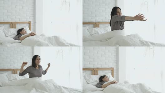 早上醒来后，女人在床上伸懒腰高清在线视频素材下载