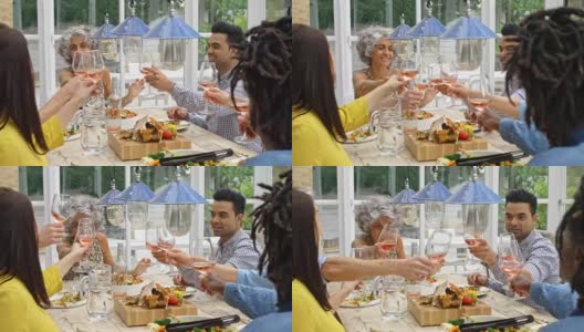 朋友们在家里吃午餐时用葡萄酒敬酒的实时视频高清在线视频素材下载