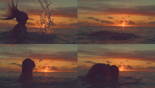 SILHOUETTE: Girl stands up out of the ocean and whips her head back at sunrise.高清在线视频素材下载