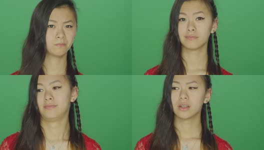 年轻的亚洲妇女环顾四周，做着傻傻的脸，在一个绿色屏幕的工作室背景高清在线视频素材下载