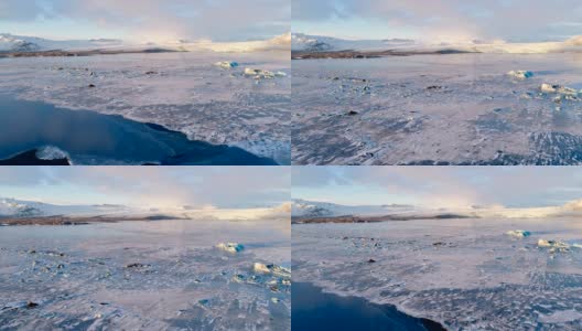 冰岛白色浮冰的鸟瞰图。我们可以看到背景中白色的大冰川，在夕阳下。高清在线视频素材下载