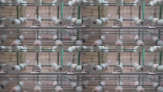 纺织厂工业整经机筒子架上的白色纱线轴高清在线视频素材下载