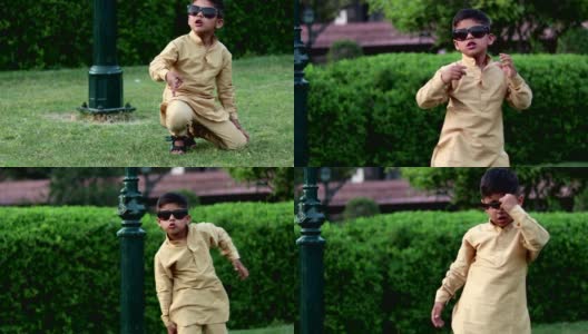 小男孩戴着太阳镜，在夏天的公园里开心地跳舞高清在线视频素材下载