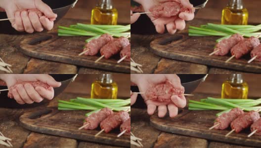 男人的手煮生烤肉串香肠串在棍子上。高清在线视频素材下载